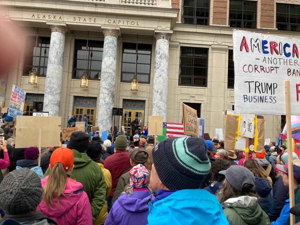 Crowd in front of the Alaska State Capital building. Dressed for warmth April 5 2025 and carrying a variety of homemade signs.