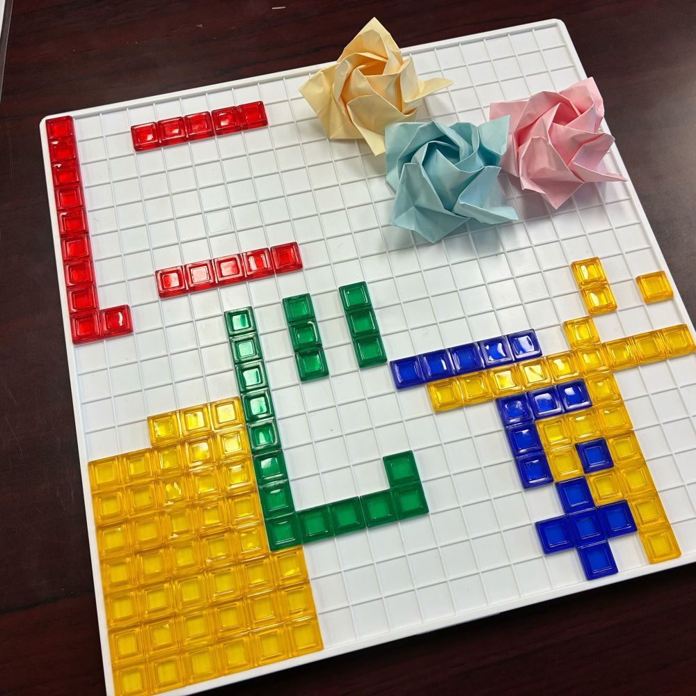 ぶろっくすのぶろっくでにじーずという文字が作られている。折り紙のばらものっている