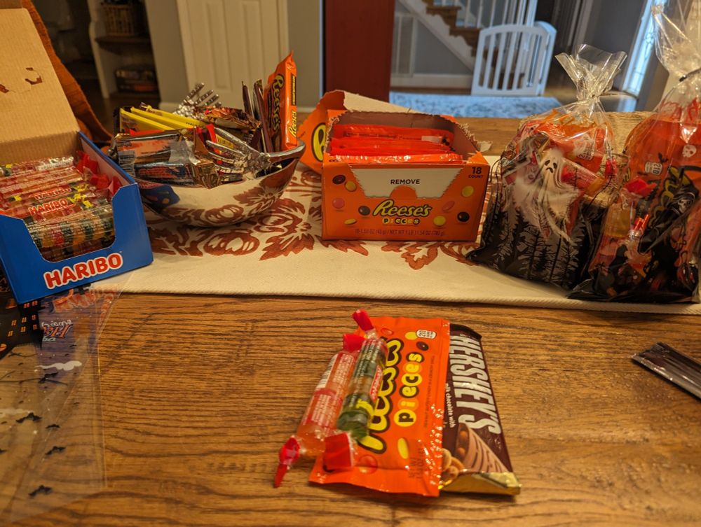 Putting a candy bag together. Full sized candy bar, a bag of Reese's pieces, and Haribo gummies.