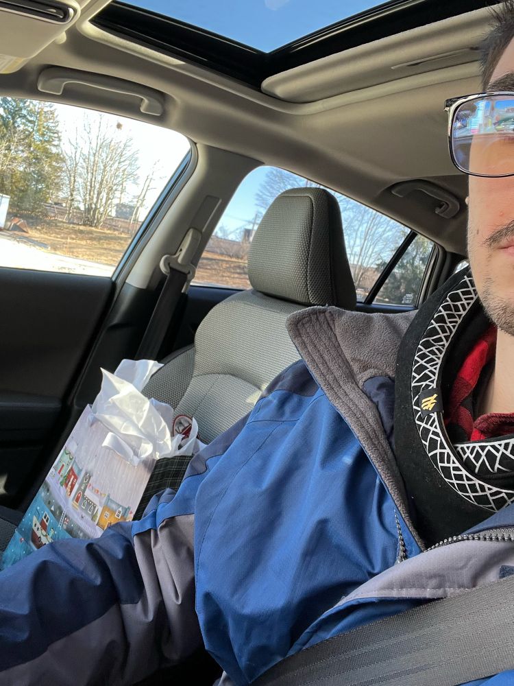 Guy driving with a present in passenger seat