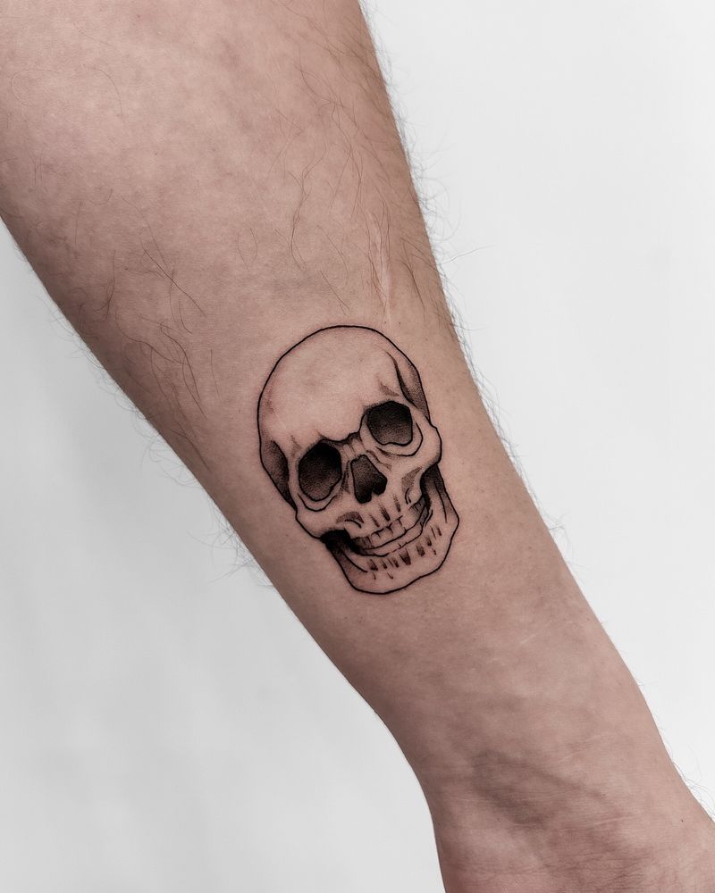 Skull tattoo around 3 inches on inner left forearm 