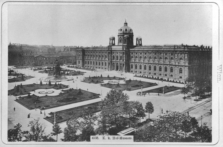 Postkarte mit einem schwarz-weiß Foto des heutigen Maria-Theresien-Platzes mit dem Naturhistorischen Museum Wien am rechten Bildrand. Beschriftung: K. k. Hof-Museum.