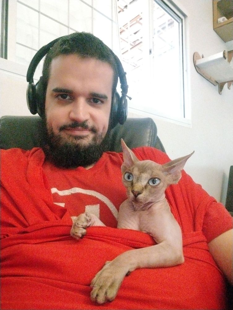 Selfie minha com a minha gata no colo quase olhando para a tela também. 