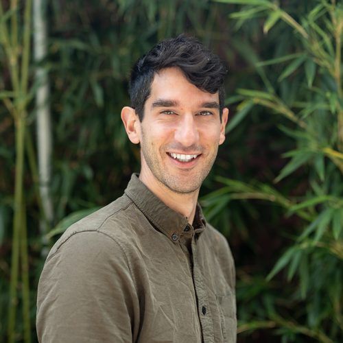 Photo of Noam Prywes standing in from of bamboo plants