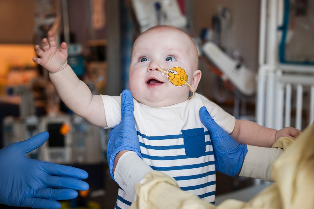 The patient, KJ, reaching out after infusion of the CRISPR therapy, with a big smile! Photo credit Children's Hospital of Philadelphia 