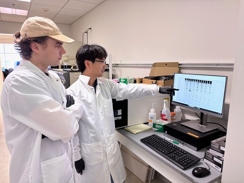 Kevin Wasko (left) and Honglue Shi in front of their gel imager, confirming that the SpRY Cas9 variant struggles to effectively open DNA