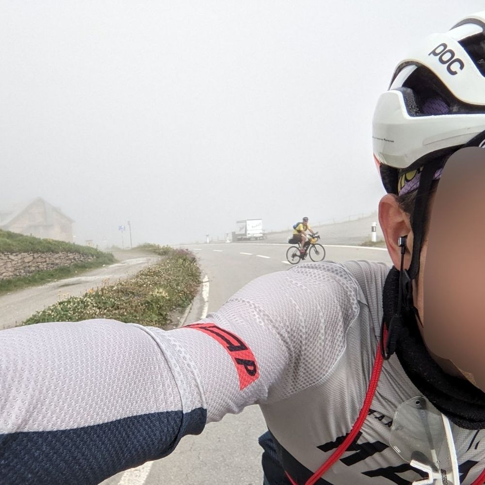 selfie auf dem rad: blick über die schulter auf ne neblige straße. im hintergrund ein anderer radly der ganz klein aussieht und als ob er meine schulter hoch fährt