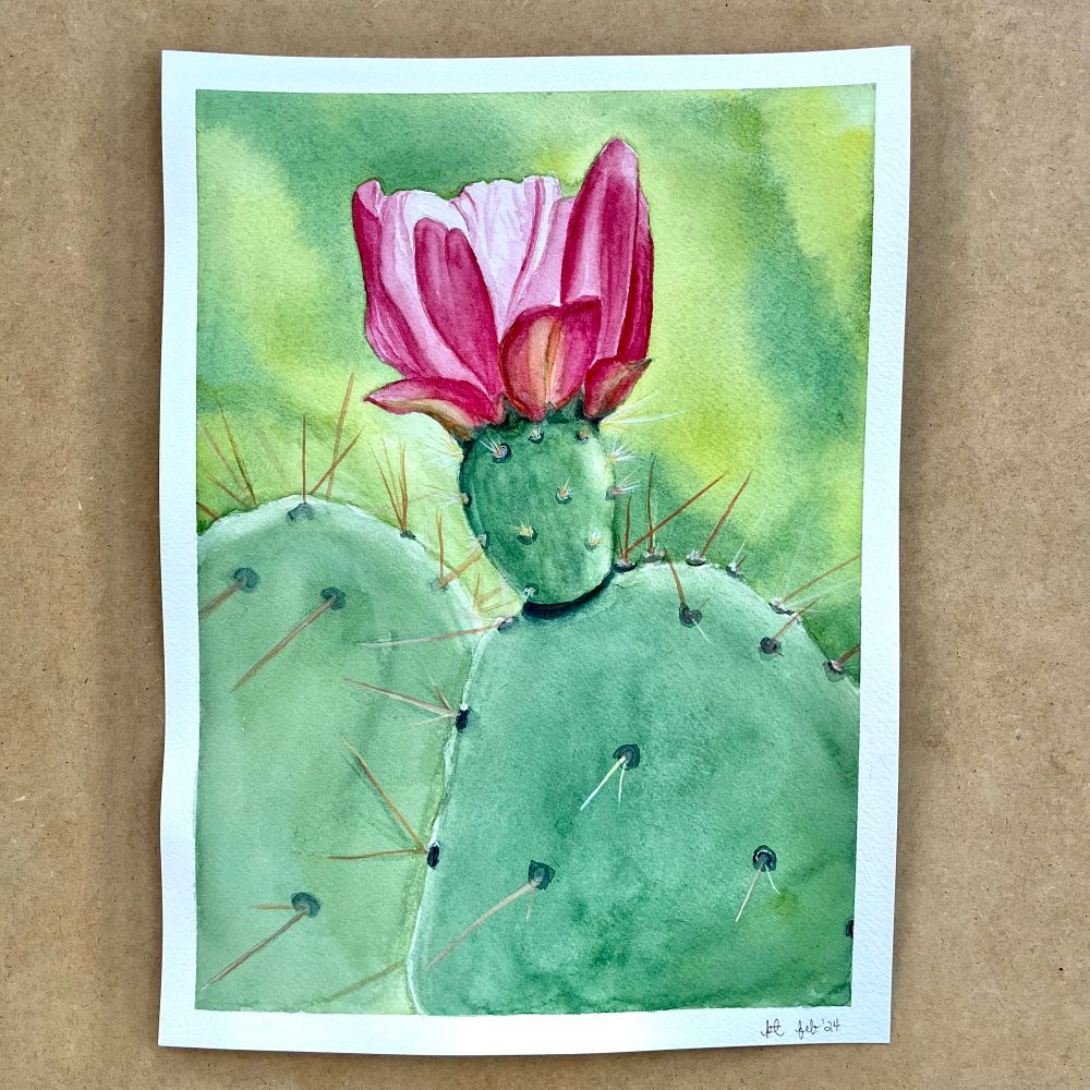Watercolor painting of a green cactus with a single pink flower in bloom