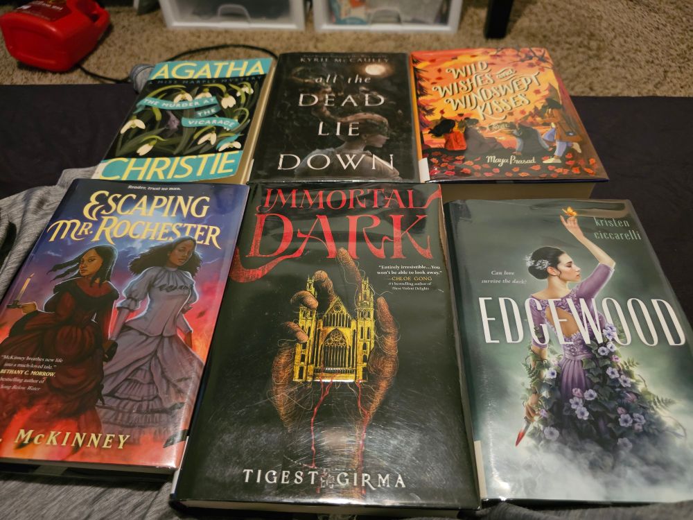 Six book covers. 

Top row, from left to right: "The Murder at the Vicarage" by Agatha Christie, "All the Dead Lie Down" by Kyrie McCauley, "Wild Wishes and Windswept Kisses" by Maya Prasad.

Bottom row, from left to right: "Escaping Mr. Rochester" by L. L. McKinney, "Immortal Dark" by Tigest Girma, "Edgewood" by Kristen Ceccarelli.