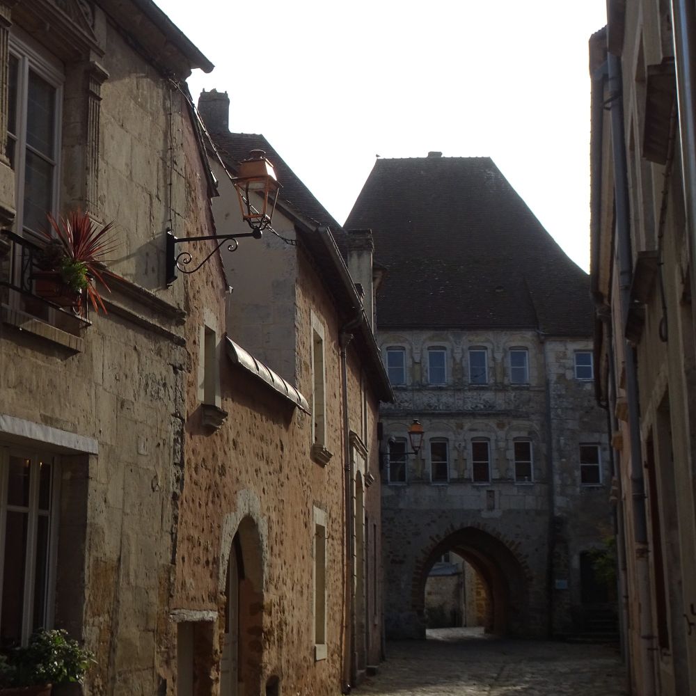 The 13th century Saint Denis gate, one of the entrance gates to the old town, at the end of a street of old, stone buildings 
