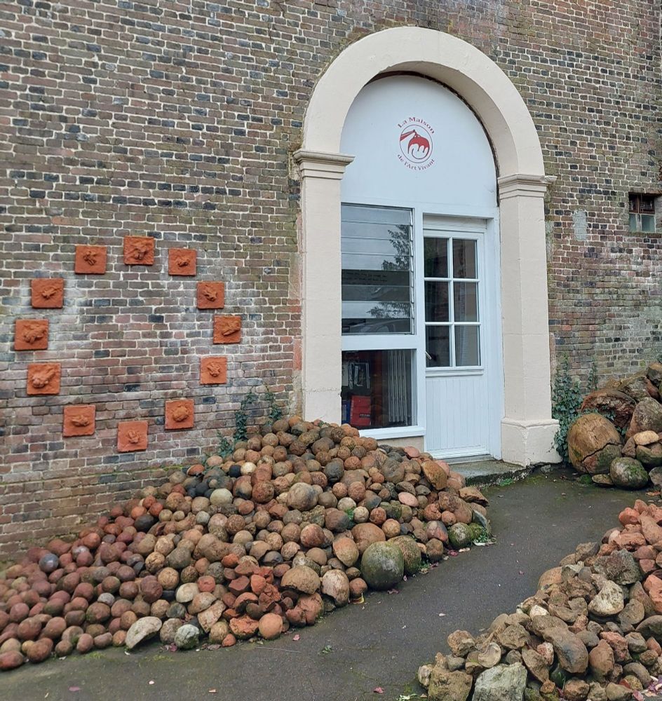 La porte d'extérieur du musée avec des tas de boules en terre cuite à côté du chemin