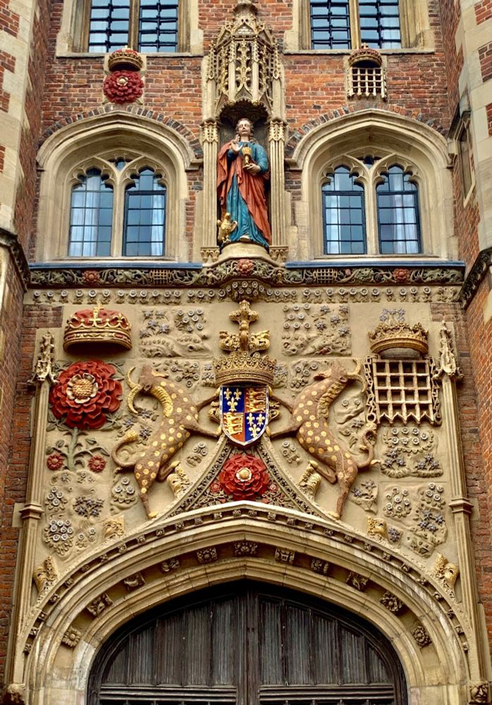 stone building gatehouse with elaborately carved statuary and heraldic emblems 