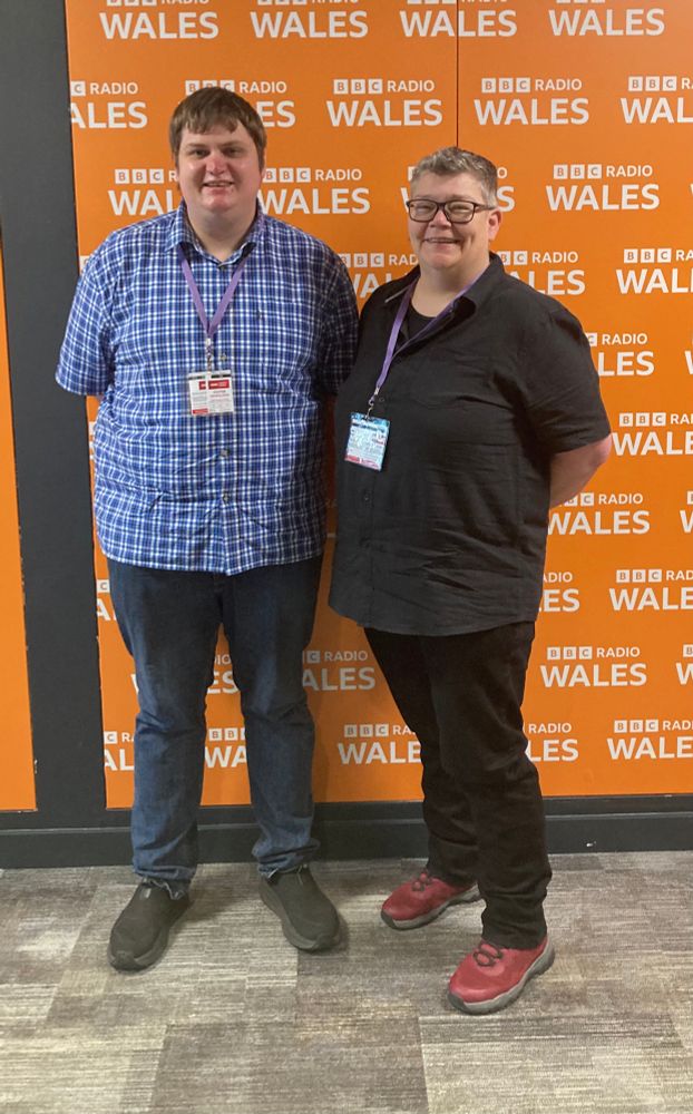 Phil and Sara stood in front of the BBC Wales logo