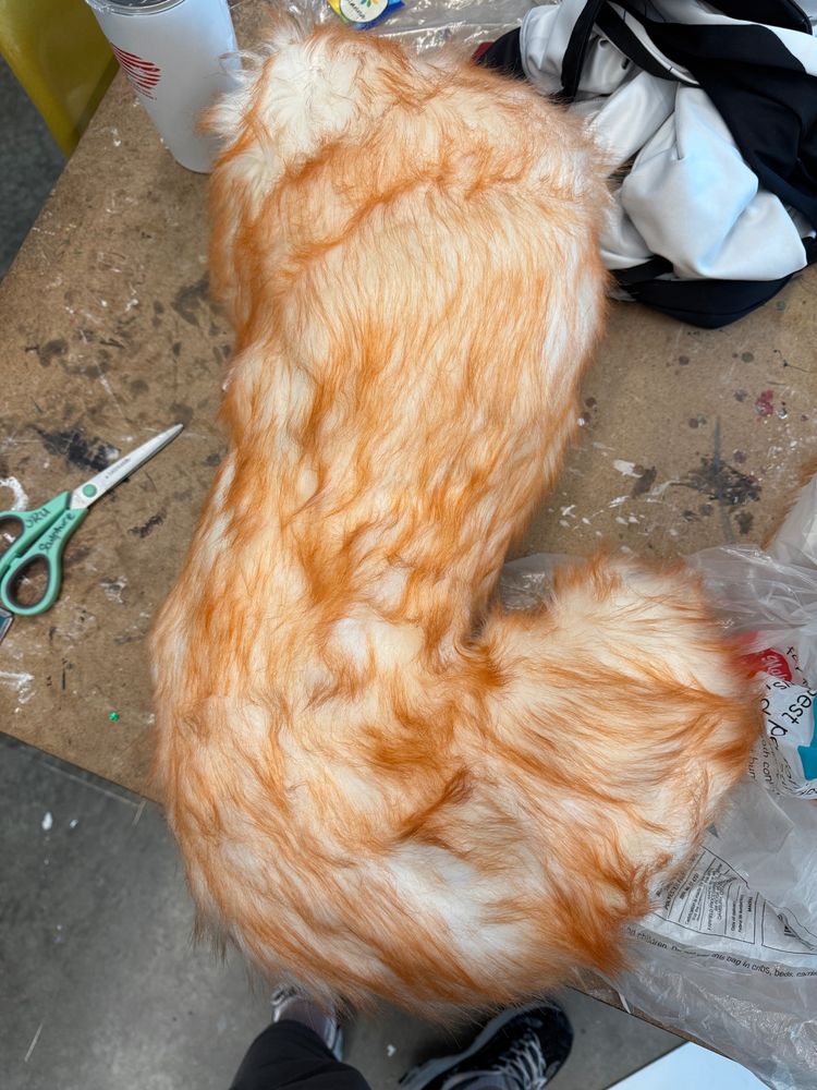 A large curved orange and white tail
The top isn’t fully sewn together yet but it is stuffed with polyfill