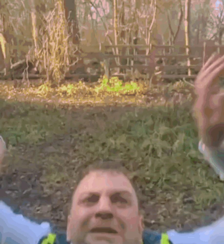 a police officer wearing a yellow vest and tie is yawning .