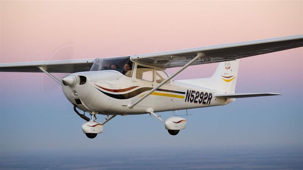 a Cessna 172 in flight - four seats, single piston engine turning a propeller up front, high wing