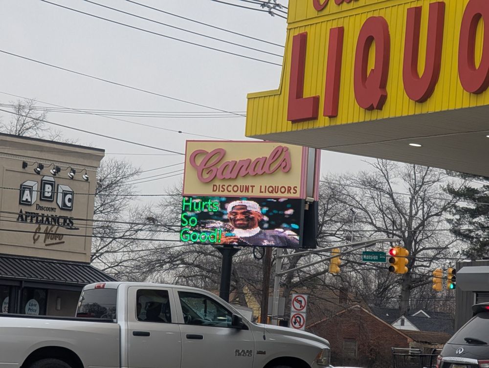 Liquor store sign that says Hurts So Good with a picture of the Super Bowl MVP