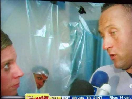 Kim Jones interviews Derek Jeter in the Yankee clubhouse during a Champagne-sprayed celebration as ARod peeks through a waterproof curtain to watch. 