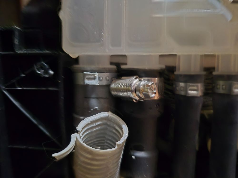 The exterior of a dishwasher, showing the cracked end of a hose.