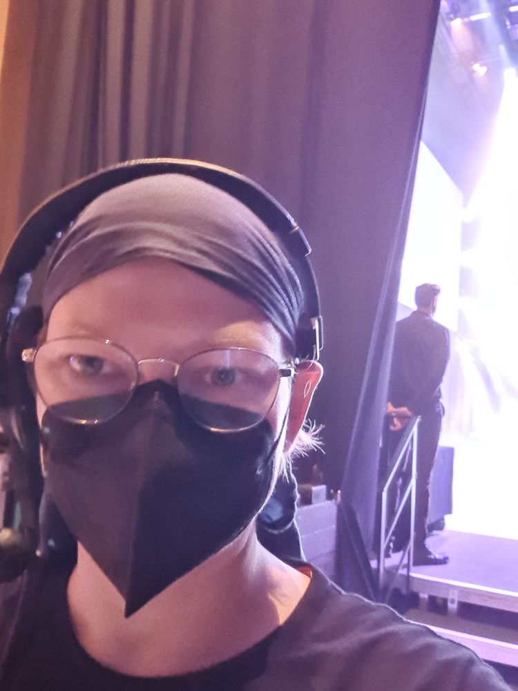selfie mit Maske und intercom. im hintergrund eine der treppen auf die Bühne)