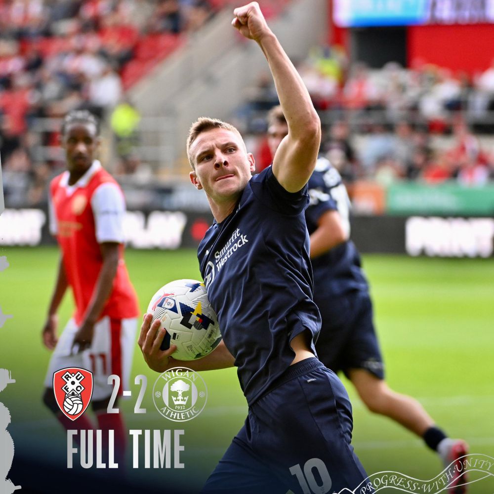 Former Wrexham AFC star and current Wigan football player Paul Mullin raises his arm in a triumphant gesture after scoring a goal in a recent match