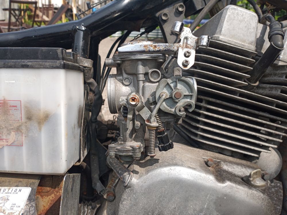 Carburetor from a 1985 Honda Rebel 250, remove from its normal position between the airbox and cylinder head, sitting atop the crankcase.