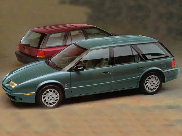 Driver's site of a teal 1994 Saturn SW2 with a red 1994 Saturn SW1 parked behind.