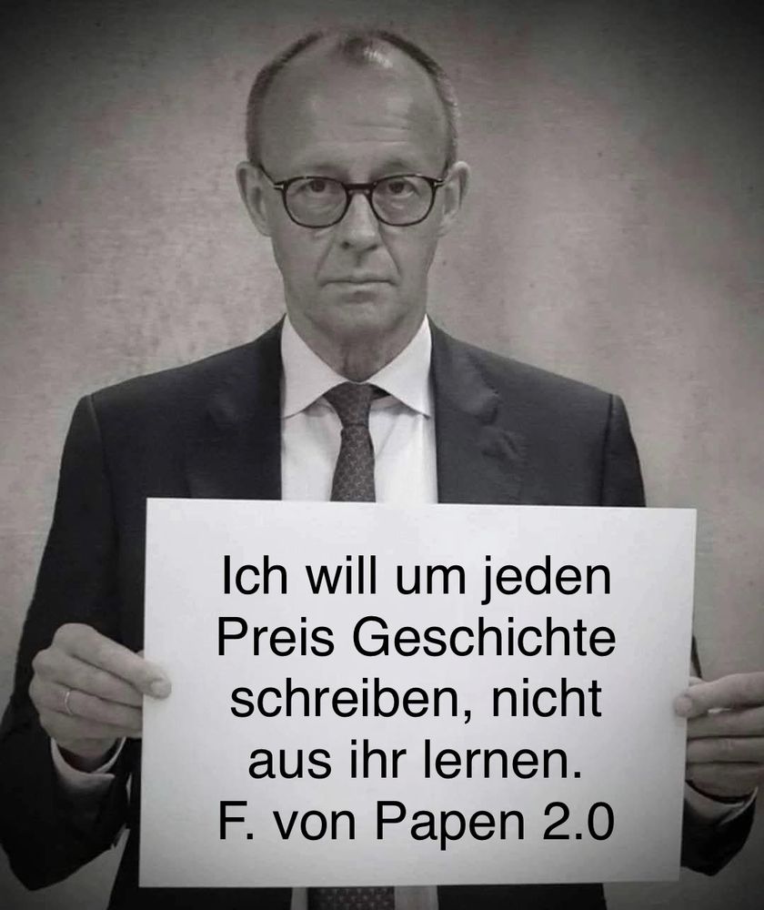 Merz mit einem Schild mit der Aufschrift: Ich will um jeden Preis Geschichte schreiben, nicht aus ihr lernen. F. von Papen 2.0