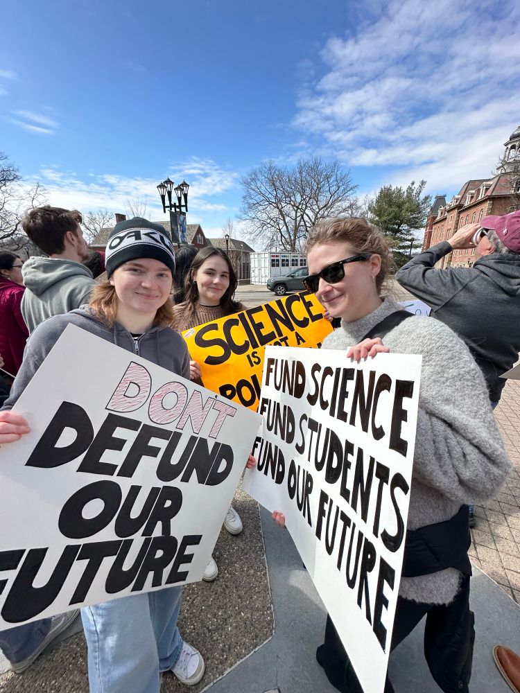 People holding signs at a public stand up for science rally 