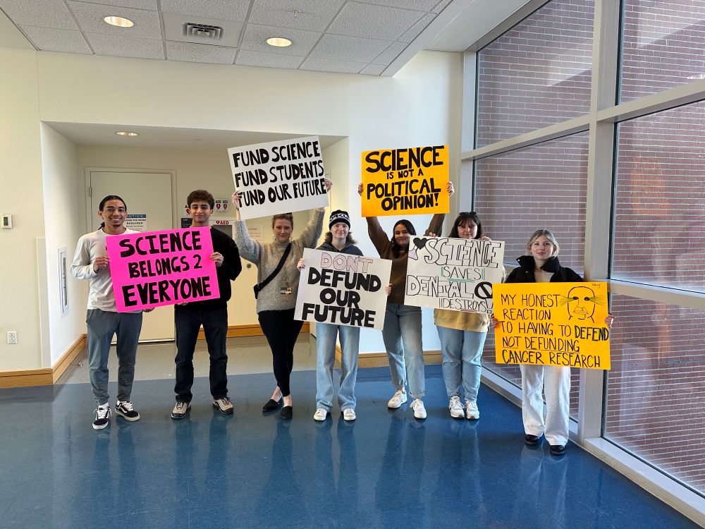 People holding signs for a public stand up for science rally