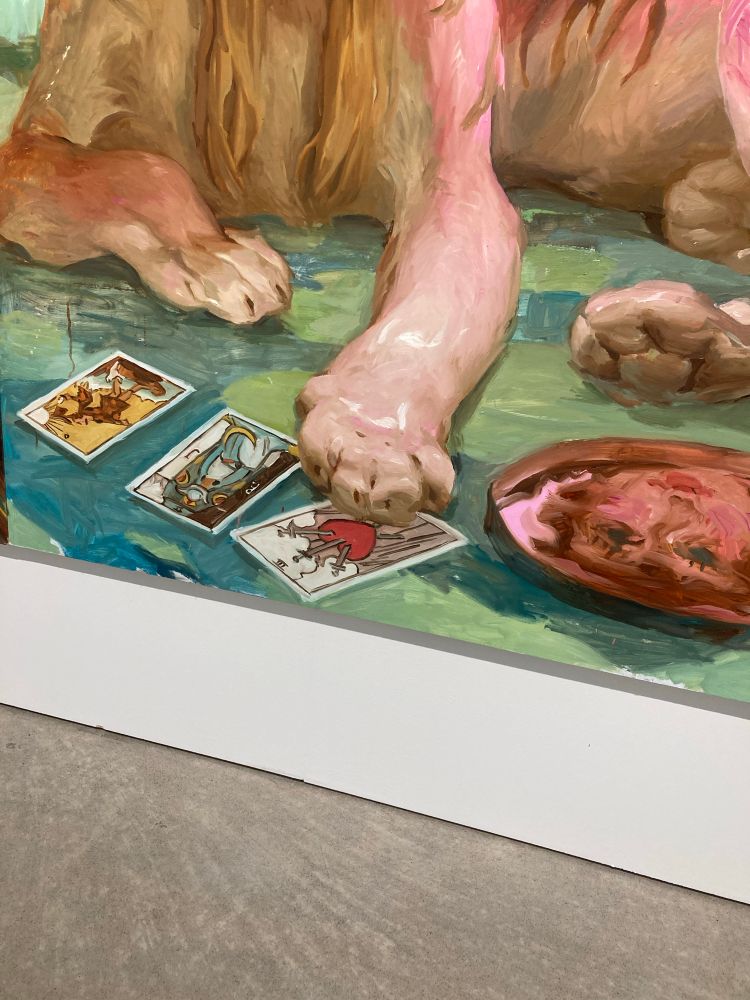 Yksityiskohta jättimaalauksesta Kuvataideakatemian kandinäyttelyssä. Maalauksessa leijonantassut, kolme tarot-korttia ja lautanen jossa jonkun räpsyripsen naama