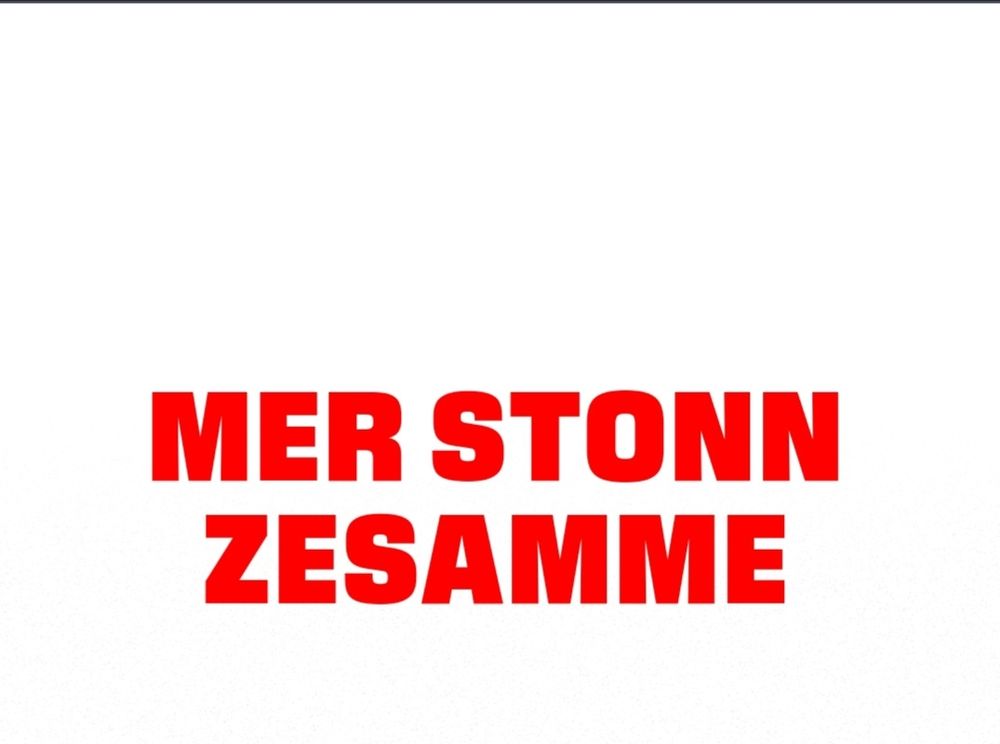 Weißer Hintergrund mit roter Aufschrift "mer stonn zesamme"
Für die Leute, die nicht aus dem Rheinland kommen, es heißt übersetzt "Wir stehen zusammen" 