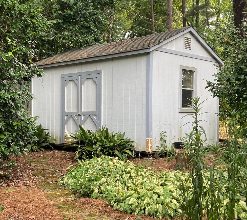 Light blue and gray storage building in backyard of a house in Hoover, Alabama.