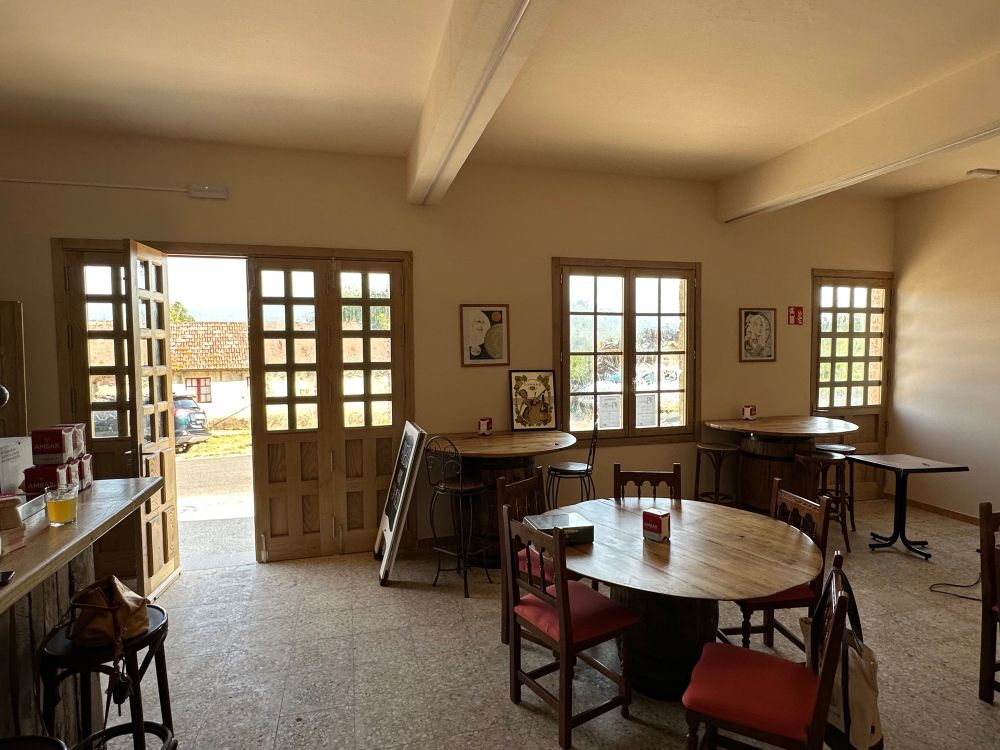 Looking outwards at the solid chestnut cafe doors, across the reclaimed wood and barrel tables