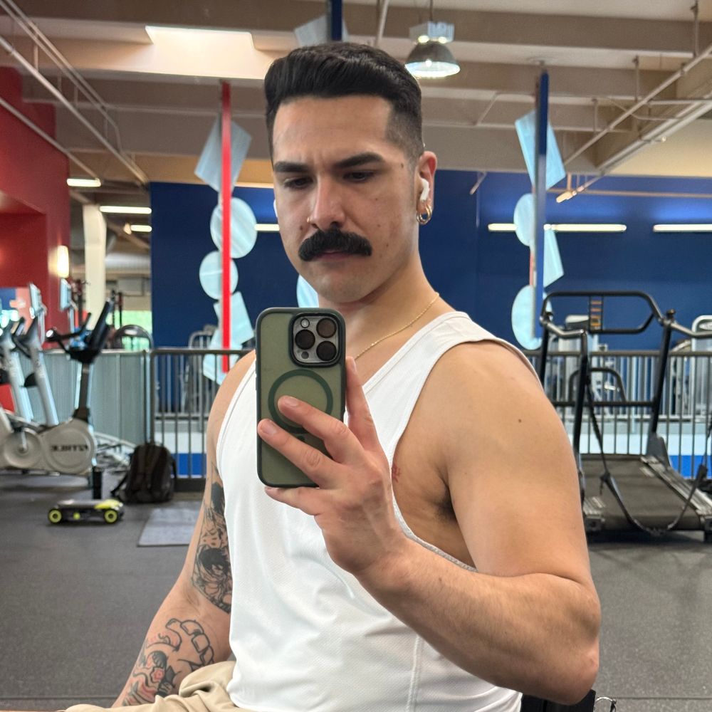 ori posing in front of a mirror at the gym