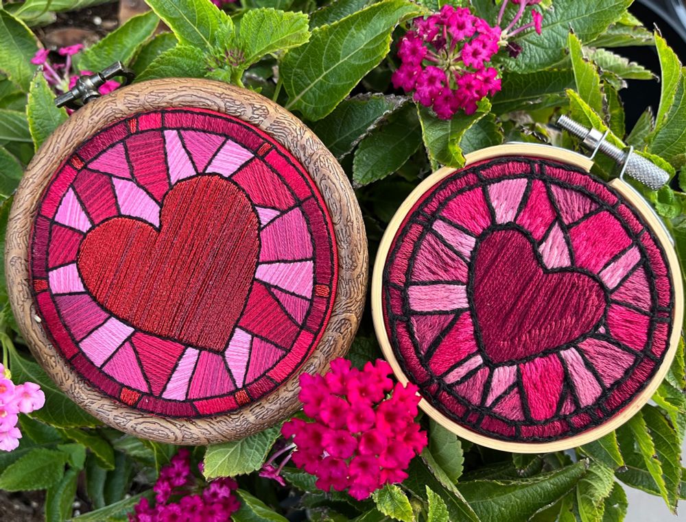 A side by side photo of the embroidery and an older one in a similar style. The design is the same, but the stitching direction and use of color to shade each section has been refined in the newer piece, which looks smoother and and less messy.
