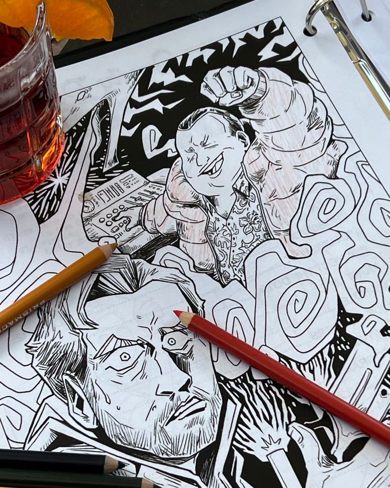 Photograph of a coloring book page depicting art of Alan Wake and Barry Wheeler. There is a negroni cocktail and some colored pencils on top of the coloring book.