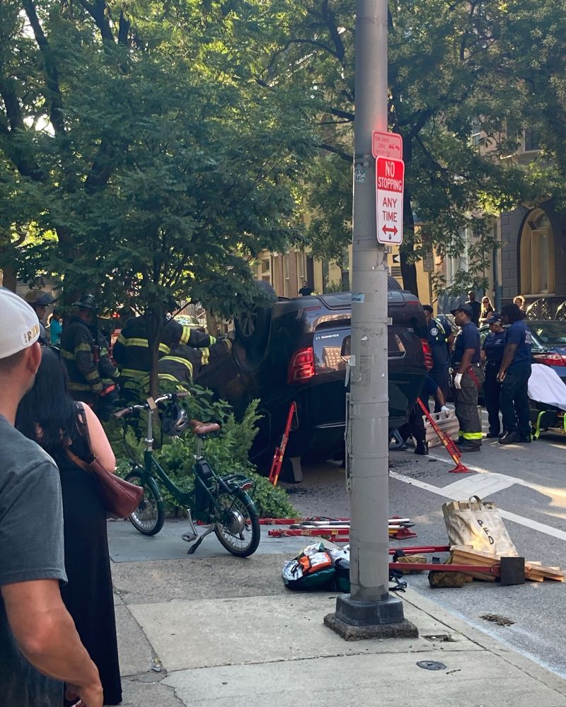 First responders working on extricating a victim from an overturned vehicle on the 900 block of spruce st.  Vehicle is an SUV overturned in the painted bike lane.