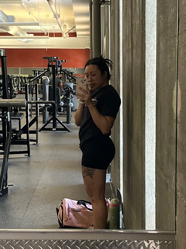 A gym mirror selfie of Amy, side profile view