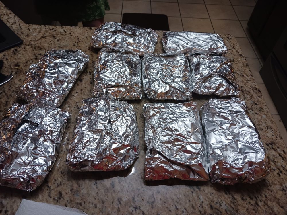 On a countertop sit ten squareish packages of aluminum foil. You cannot tell that they contain lasagna, but they do.