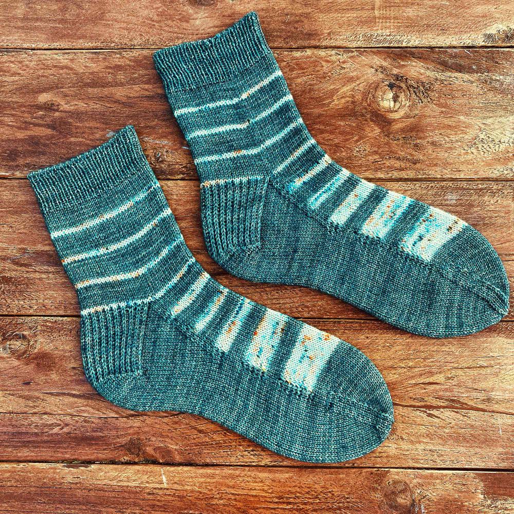 A pair of hand knitted socks using intarsia technique on the foot. 