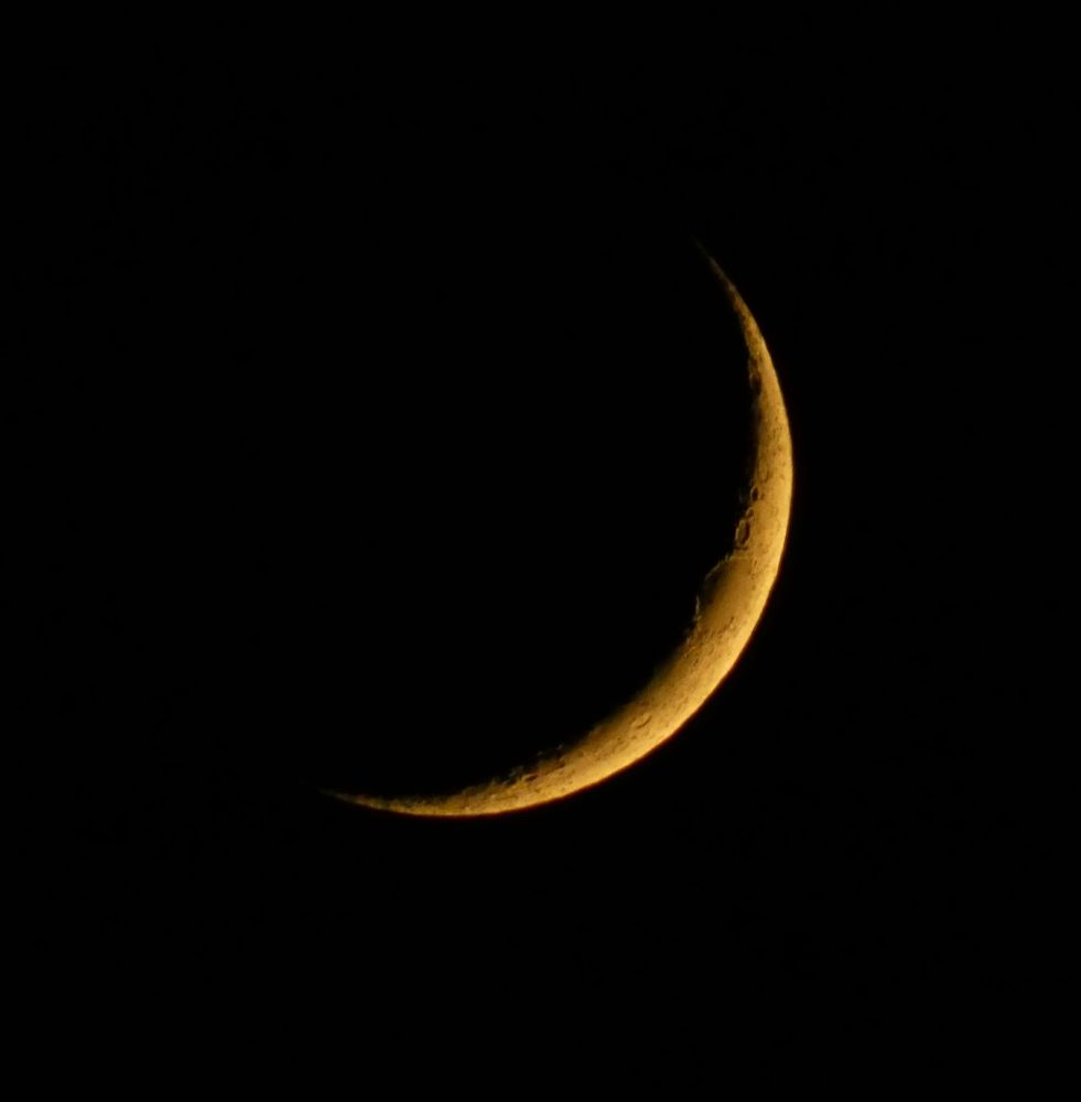 A crescent moon glowing against a dark night sky.