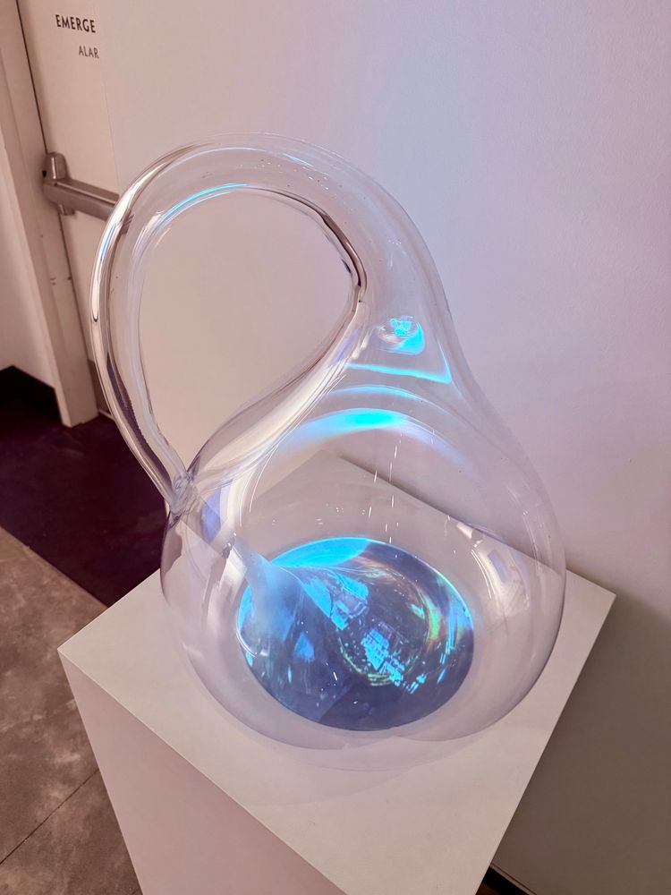 Large glass Klein bottle with video of its creation projected onto the bottom