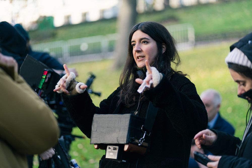 Photo shows Laura directing the film, surrounded by actors and film workers.