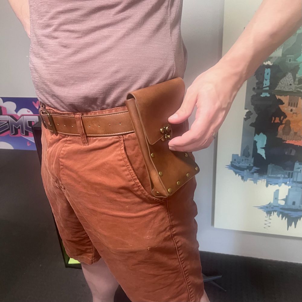 Rhaps wearing the leather dice pouch like a holster.