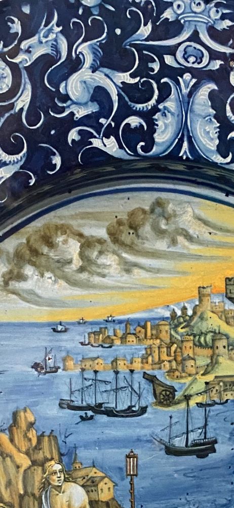 Detail of stormy sky and port city depicted on a maiolica plate.
