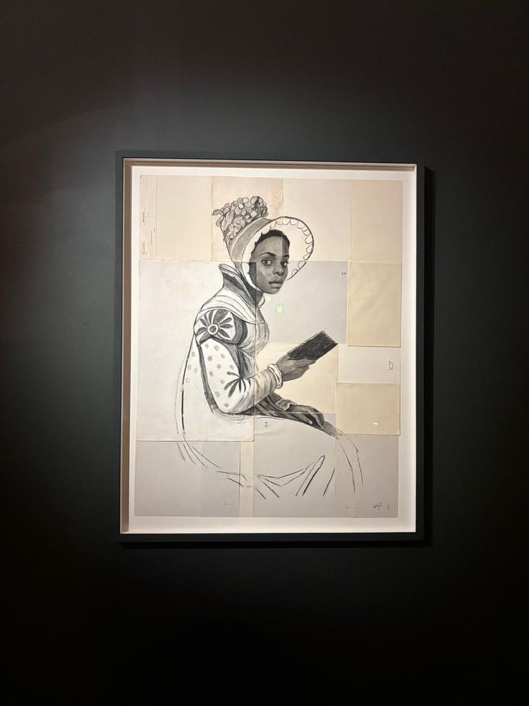 A charcoal portrait of a women of colour sat on a rock, book in hand wearing a gown, spencer and bonnet looking at the viewer