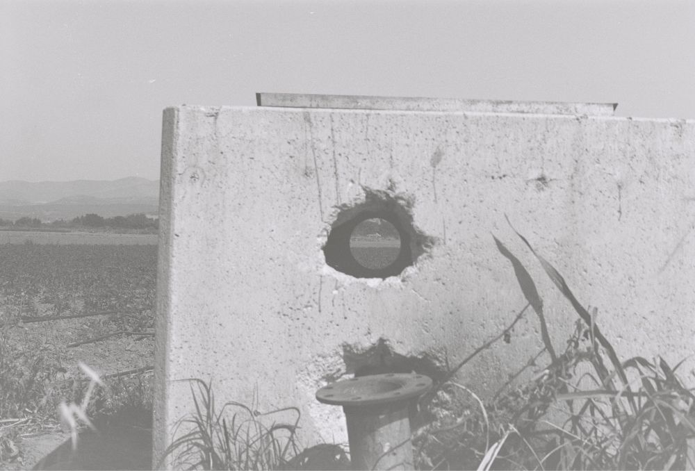 Yol kenarında bulunan tarlanın atıl durumdaki su deposu, deliğin tam içinde araba var.