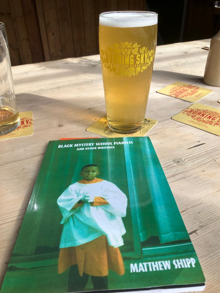 A pint of Burning Sky NZPA and Matthew Shipp’s ‘Black Mystery School Pianists’  book on a wooden table in The Evening Star pub in Brighton. 
