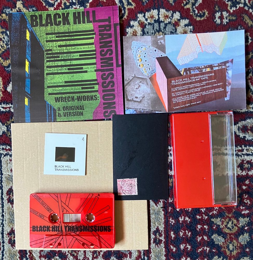 A red cassette and cassette case. Assorted ephemera including a slide, a black card with a stamp on it. Text on one insert reads: 

BLACK HILL TRANSMISSIONS
TRANSMISSION #4' TAPE
V/ WRECK-WORKS(ORIGINAL) / WRECK-WORKS
TAPE VERSION) / LEFT HAND PATH
B// TAPEHISS #2 / LEATHEROID (VERSION) / 0698 BEAT /
WE (DEMO) / PLASTIC DRUID
ALL MADE UP BY MARK SCANLAN, AT HOME 2023-25 WRECK-WORKS (ORIGINALY ORIGINALLY MASTERED
BY STEPHEN BUCKLEY
"artists bury night, wreck ears"
